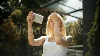 年轻的金发女人<strong>看</strong>着智能<strong>手机</strong>上的反光，她的头发用<strong>手机</strong>做镜子